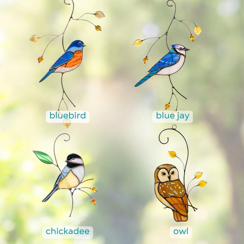 May include: Four colorful stained glass bird ornaments: a bluebird, a blue jay, a chickadee, and an owl. Each bird is perched on a delicate metal branch with leaves. The names of the birds are written below each image.