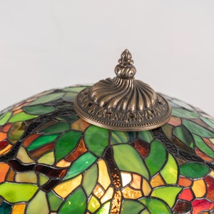 a cap on the flower lampshade made of modern stained glass