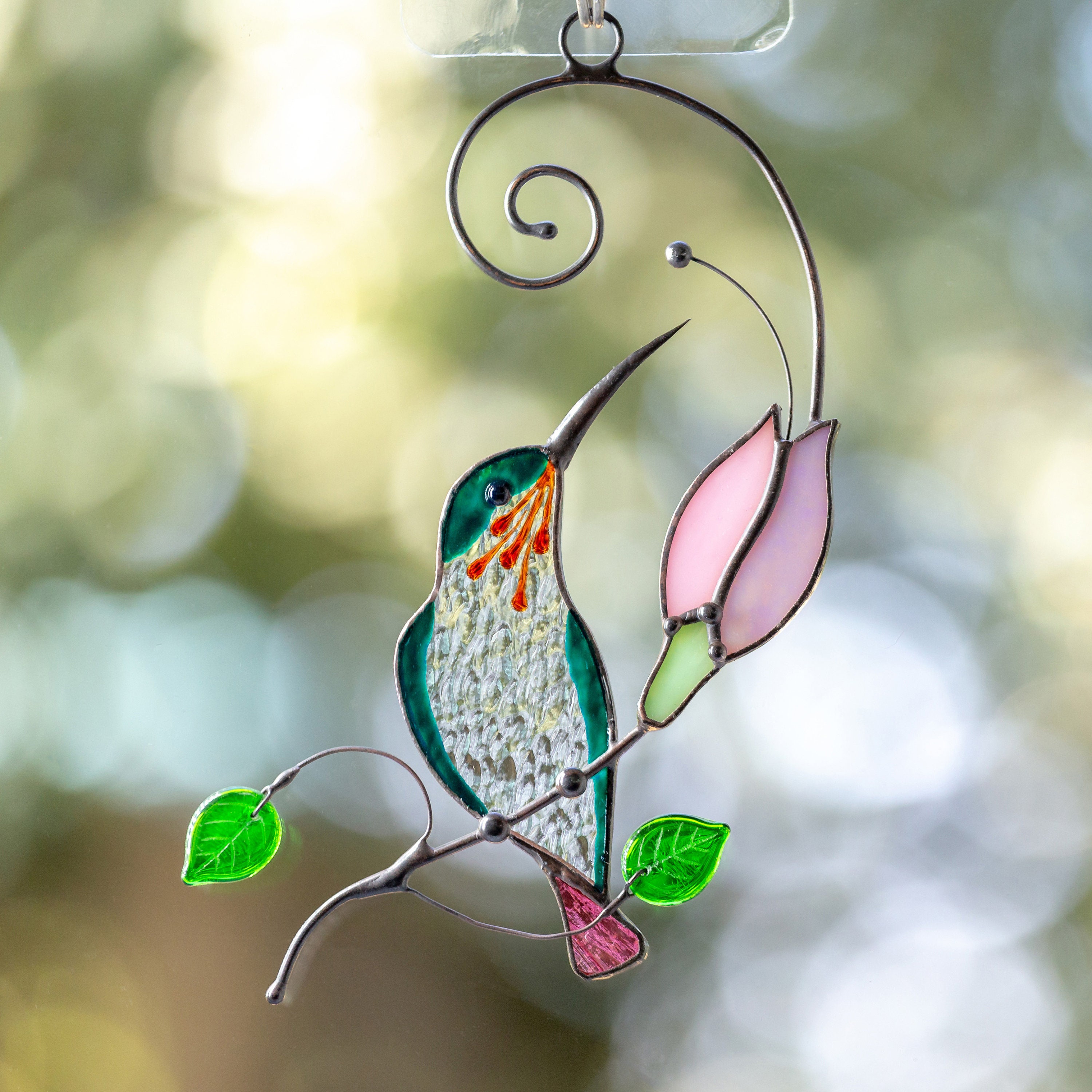 This tender stained glass hummingbird suncatcher is a lovely decor for your...