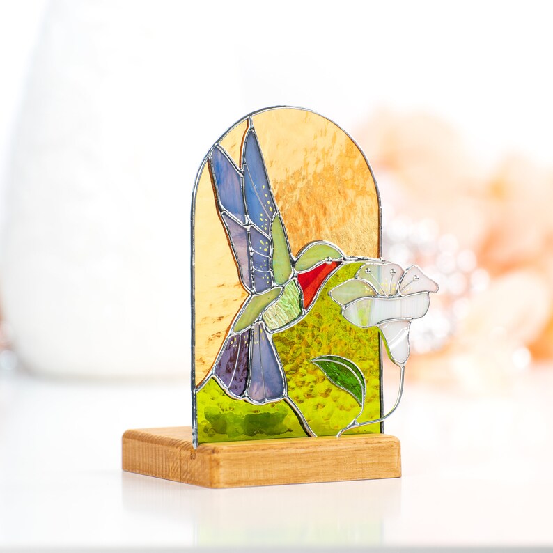 flying bird to the flower made of stained glass and fixed on the wood base