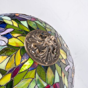 the bronze cap on the stained glass lamp