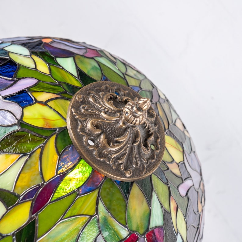 the bronze cap on the stained glass lamp