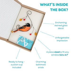Open gift box showing a stained glass oriole, a suction cup, and branded card, with descriptive arrows pointing to product features.