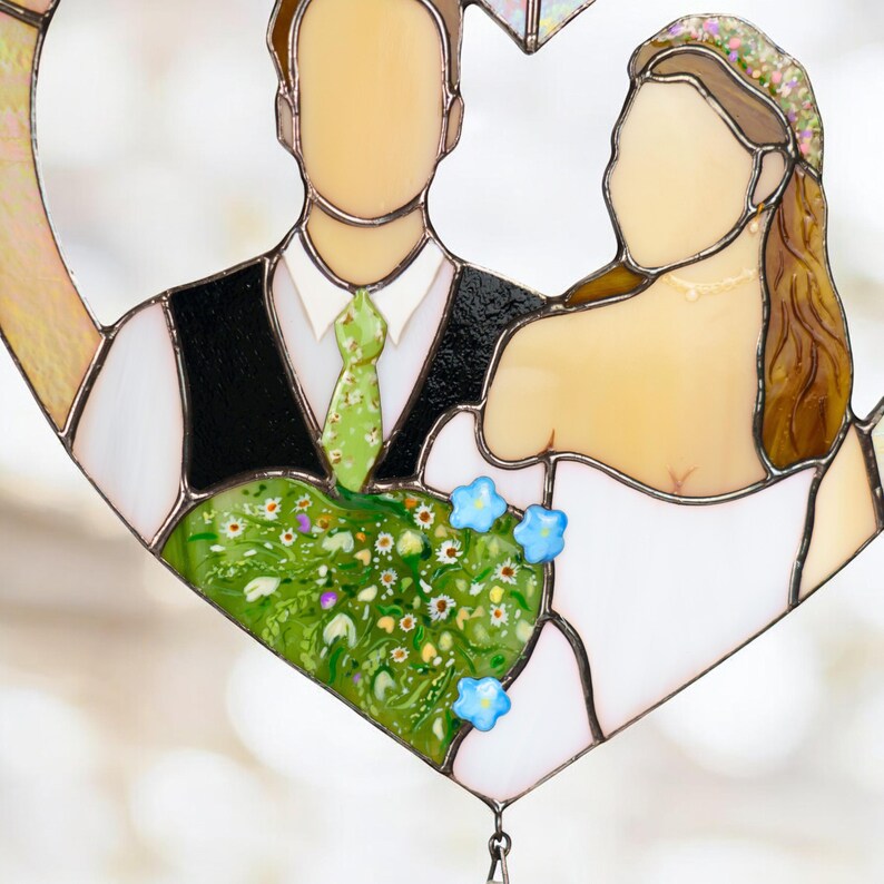 Detailed close-up of the stained glass wedding couple showing floral details and soft blurred background.
