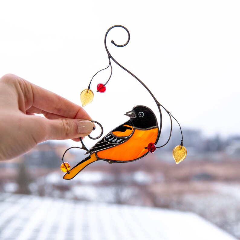 orange stained glass bird suncatcher with red berries and yellow leaves