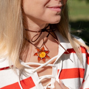 woman is wearing the sun pendant made of stained glass
