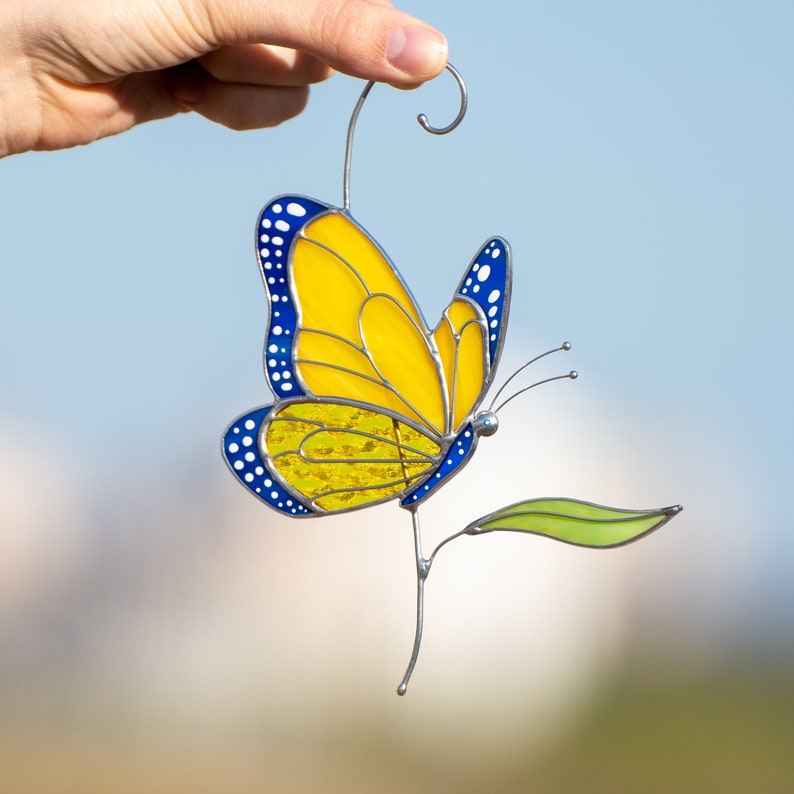 blue and yellow monarch butterfly ornament made of stained glass