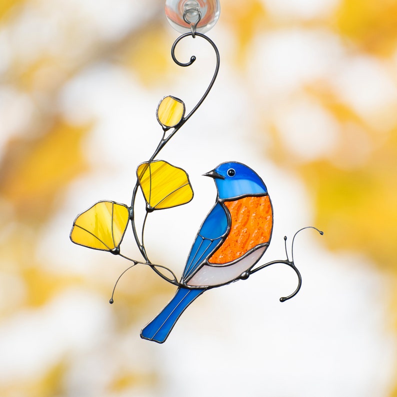bluebird sitting on the branch with yellow leaves stained glass window hanging