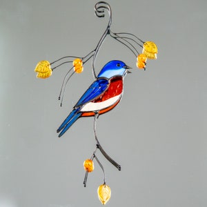 glass light catcher of bluebird with leaves and berries