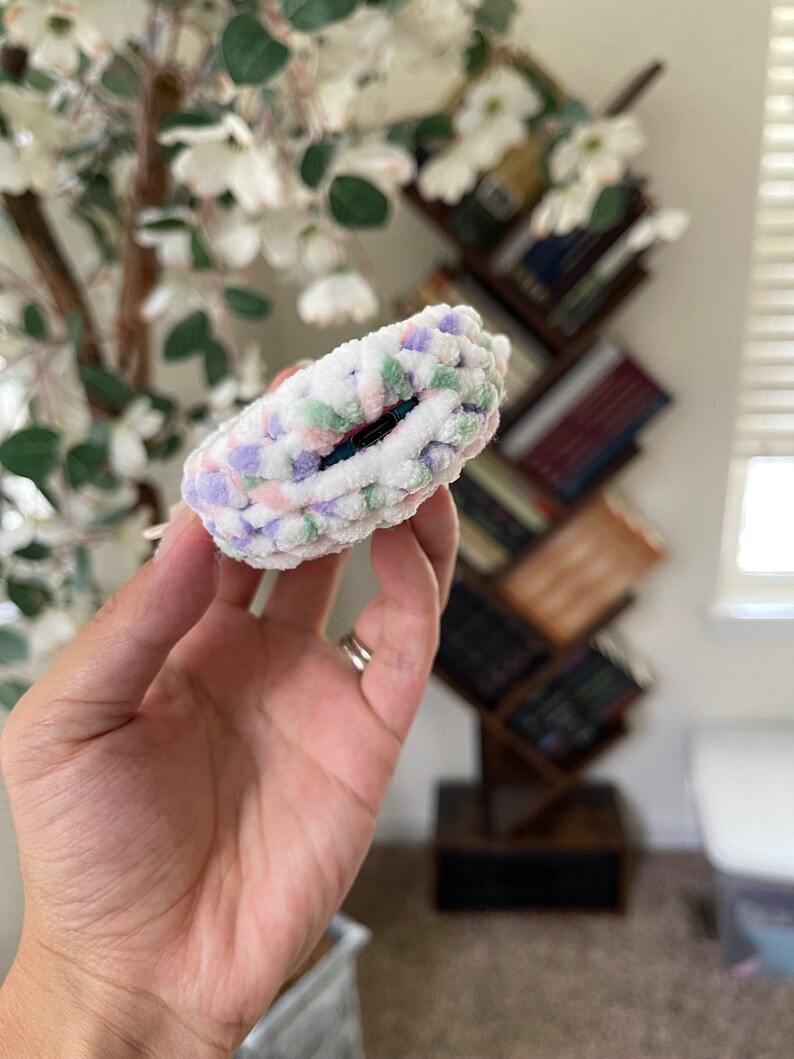 May include: A white, pink, green and purple fuzzy hair scrunchie.