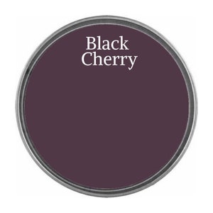 May include: A round paint can lid with the text "Black Cherry" in white lettering on a dark purple background.