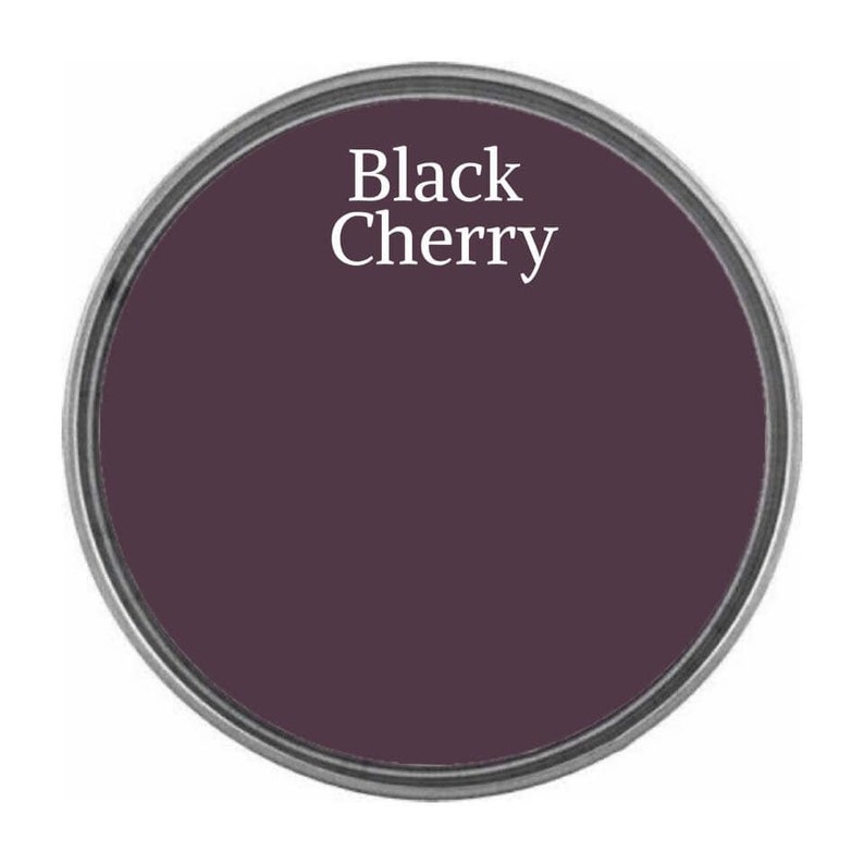 May include: A round paint can lid with the text "Black Cherry" in white lettering on a dark purple background.