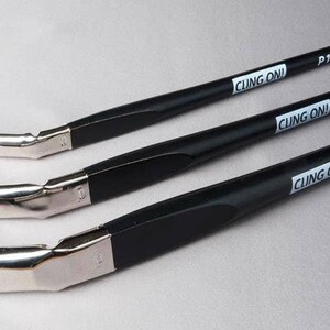 May include: Three angled paint brushes with black handles and silver ferrules. The brushes have brown and white bristles. The text "CLING ON!" is printed on the handles, along with the sizes P16, P20, and P24.