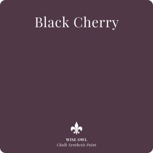 May include: A paint can label with the text "Black Cherry" and the Wise Owl Chalk Synthesis Paint logo. The background is a dark purple color.