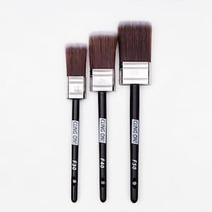 May include: Three paint brushes with black handles and brown bristles are displayed against a white background. The brushes are labeled F30, F40, and F50, with the text "CLING ON!" printed on the handles. The bristles have a white edge.