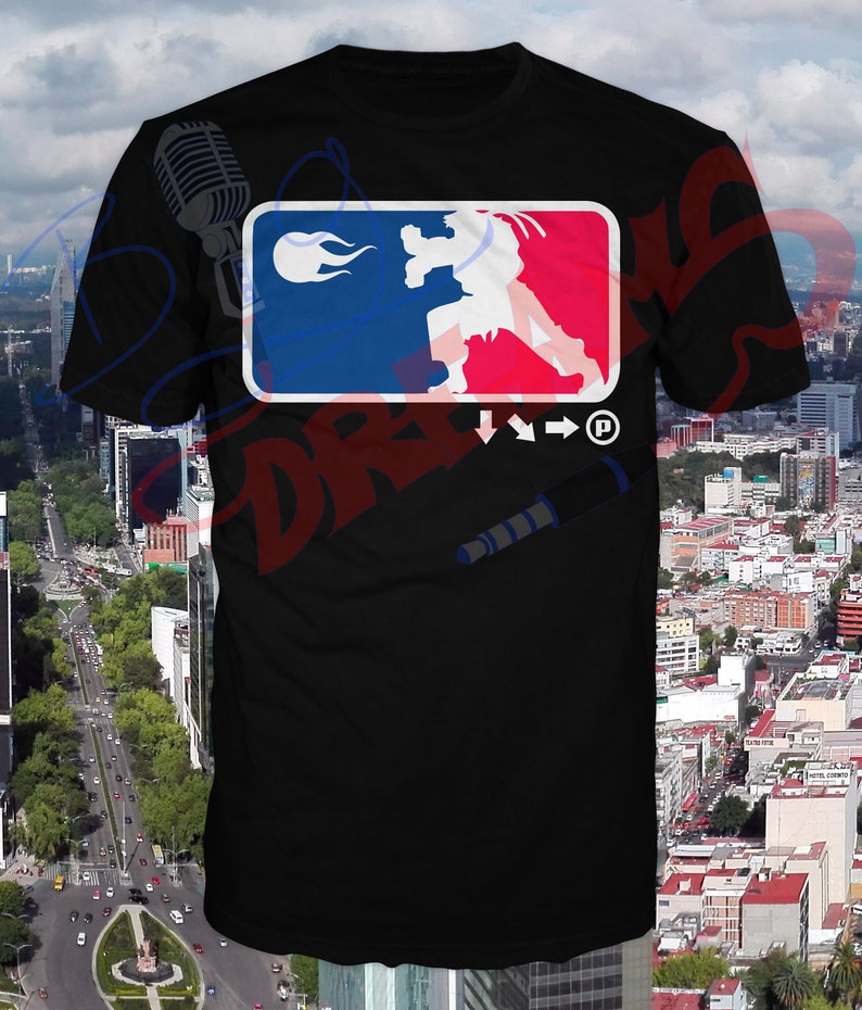 May include: Black t-shirt with a graphic of a fighting video game character in a blue and red logo with flames. The logo also includes the text "Street Fighter" and a copyright symbol.