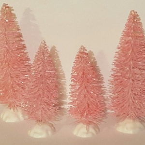 Może przedstawiać: Cztery różowe drzewa z pędzlem do butelek z białymi podstawami. Drzewa mają różne rozmiary i błyszczące wykończenie.