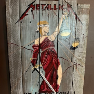 May include: A wooden sign with a painted image of a blindfolded figure holding a scale and sword. The text "METALLICA...AND JUSTICE FOR ALL" is painted on the sign.