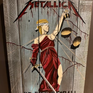 May include: A wooden sign with a painted image of Lady Justice holding a sword and scales. The sign is painted in shades of gray, red, and gold. The text "METALLICA...AND JUSTICE FOR ALL" is painted on the bottom of the sign.