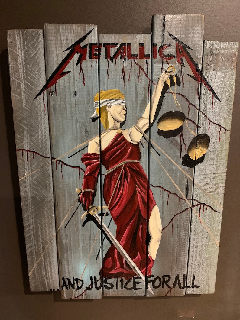 May include: A wooden sign with a painted image of Lady Justice holding a sword and scales. The sign is painted in shades of gray, red, and gold. The text "METALLICA...AND JUSTICE FOR ALL" is painted on the bottom of the sign.