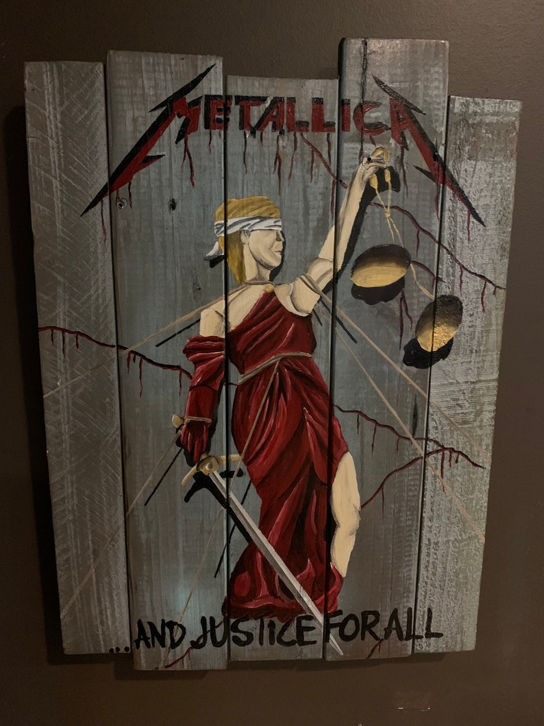 May include: A wooden sign with a painting of the Lady Justice holding a sword and scales. The sign is painted in shades of gray, red, and gold. The text "...AND JUSTICE FOR ALL" is written at the bottom of the sign. The text "METALLICA" is written at the top of the sign.