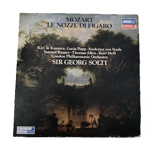 Puede incluir: Una portada de álbum de vinilo vintage que presenta una pintura de una escena de jardín con personas en primer plano. El álbum es para la ópera Le Nozze di Figaro de Mozart, con la Orquesta Filarmónica de Londres dirigida por Sir Georg Solti.