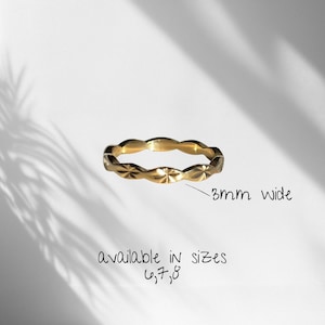 Peut inclure: Une bague dor&eacute;e orn&eacute;e d'un motif en &eacute;toile r&eacute;p&eacute;t&eacute; sur tout l'anneau. La bague mesure 3 mm de large et est disponible dans les tailles 6, 7 et 8, comme indiqu&eacute; par le texte pr&eacute;sent sur l'image.
