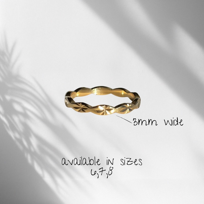 Peut inclure: Une bague dor&eacute;e orn&eacute;e d'un motif en &eacute;toile r&eacute;p&eacute;t&eacute; sur tout l'anneau. La bague mesure 3 mm de large et est disponible dans les tailles 6, 7 et 8, comme indiqu&eacute; par le texte pr&eacute;sent sur l'image.