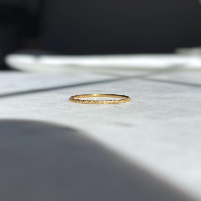 thin gold ring with a sparkly stardust finish