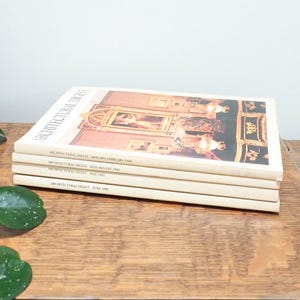 Könnte beinhalten: Ein Set aus drei Keramikbechern mit gesprenkelter, matter Oberfläche. Jeder Becher hat eine andere Farbe: hellblau, cremefarben und grau. Die Becher haben ein schlichtes, modernes Design mit runder Form und bequemem Griff.