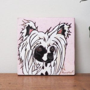 May include: Square ceramic tile with a Chinese Crested dog portrait. The dog has white fur, black markings, and a pink background. The tile is hand-painted with the name "Pumpkin" in the bottom right corner.