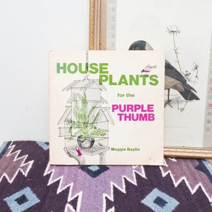 May include: A vintage book titled "House Plants for the Purple Thumb" by Maggie Baylis. The cover features a green plant in a wire cage.