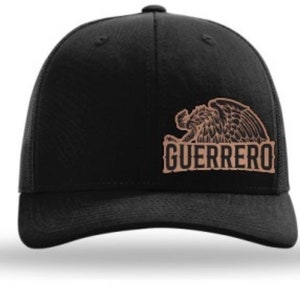 May include: Black trucker hat with a brown embroidered eagle and the word "GUERRERO" on the front.