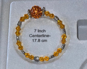 Pulsera elástica con cristales bicónicos de oro amarillo y cuentas de metal en forma de hoja de plata