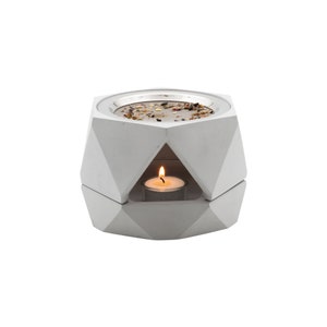 Op de afbeelding: Witte geometrische betonnen wierookbrander met een metalen gaas inzet en een kleine theelichtje in het midden.