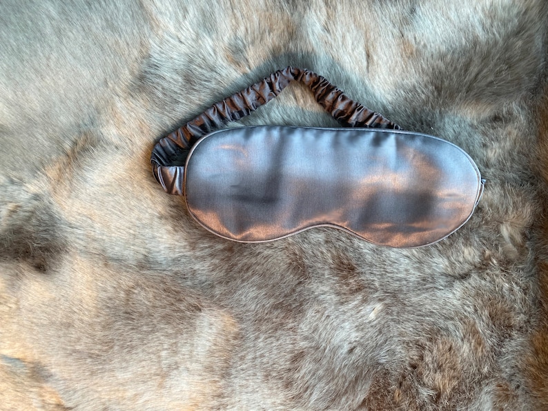 May include: A gray silk sleep mask with an elastic band.