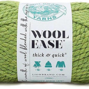 May include: A ball of green yarn with a white label that reads "WOOL-EASE thick & quick" from Lion Brand Yarns. The yarn is a thick, textured wool blend, ideal for knitting or crocheting projects. The label features icons of a scarf, hat, and sweater.