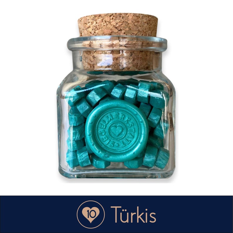 May include: A glass jar filled with teal wax sealing beads. The jar has a cork lid and a teal wax seal with the text "Siegelwerkstatt" and a heart.