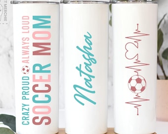 May include: White insulated tumblers with lids and straws. One tumbler reads "CRAZY PROUD ALWAYS LOUD SOCCER MOM" in teal, pink, and brown. Another has the name "Natasha" in teal script. The third features a soccer ball and heartbeat design.