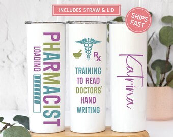 May include: Three white stainless steel tumblers with a black, green, and purple design. The tumblers are labeled "Pharmacist", "Training to Read Doctors' Handwriting", and "Katrina".