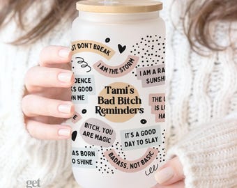 May include: A frosted glass tumbler with a bamboo lid and a clear straw, featuring a colorful graphic print with black text that reads Tami's Bad Bitch Reminders, I am the storm, Bitch, you are magic, It's a good day to slay, and Badass, not basic.