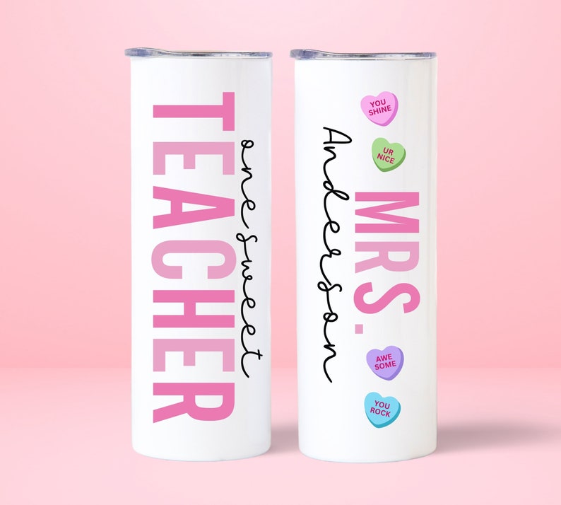 May include: Two white stainless steel tumblers with pink and black text. One tumbler says "Teacher" with a pink ombre effect and "One Sweet" written in cursive. The other tumbler says "Mrs. Anderson" with pink hearts that say "You Shine", "Ur Nice", "Awe Some", and "You Rock".