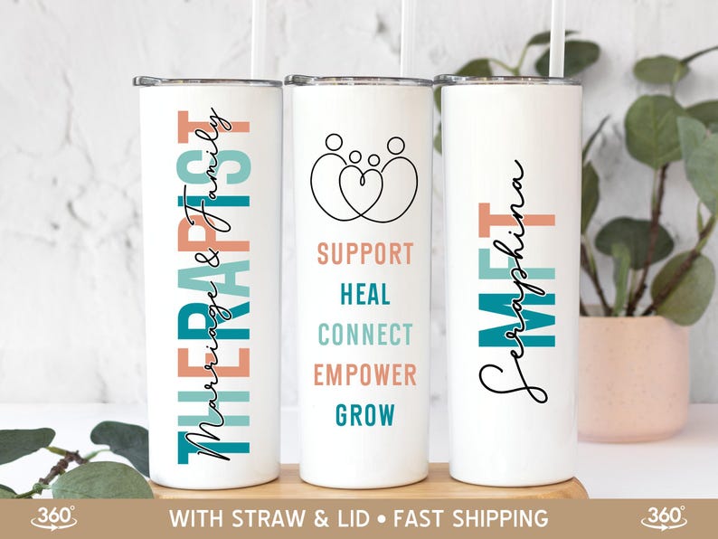 May include: Three white tumblers with colorful text and designs. The tumbler on the left says "Marriage & Family Therapist". The tumbler in the middle says "Support, Heal, Connect, Empower, Grow". The tumbler on the right says "Seraphina Meet".