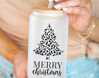May include: White frosted tumbler with a bamboo lid and a black and white leopard print Christmas tree design. The tumbler has the text "Merry Christmas" printed on it.