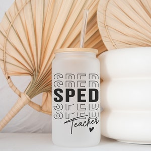 May include: White frosted glass tumbler with a bamboo lid and a black and white graphic that says "SPED Teacher" with a small heart. The tumbler is sitting on a white surface with a straw.