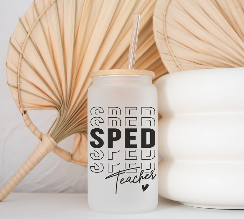 May include: White frosted glass tumbler with a bamboo lid and a black and white graphic that says "SPED Teacher" with a small heart. The tumbler is sitting on a white surface with a straw.