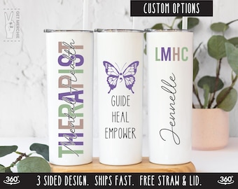 Könnte beinhalten: Drei weiße Edelstahlbecher mit unterschiedlichen Designs. Der erste Becher hat den Text "Mental Health Therapist" in Grün, Braun und Lila. Der zweite Becher hat einen lila Schmetterling mit einem Semikolon auf dem Flügel und den Text "Guide Heal Empower". Der dritte Becher hat den Text "LMHC" in Grün, Braun und Lila und den Text "Jennelle" in Schwarz.