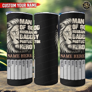 May include: Black tumbler with a lion graphic and the words "MAN OF GOD, HUSBAND, DADDY, PROTECTOR, HERO". The tumbler includes space for a custom name and a list of words like "MADE NEW" and "LOVED".