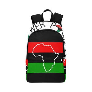 May include: Black backpack with red, black, and green stripes featuring a white outline of the continent of Africa. The backpack has the words "Power" and "Pride" printed on it.