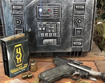May include: A silver metal case with a detailed design, a black and gold box with the text "Old V7 71c", a black and silver pistol, and several gold and silver tokens.